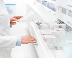 Un pharmacien ouvrant un tiroir contenant des anti-douleurs