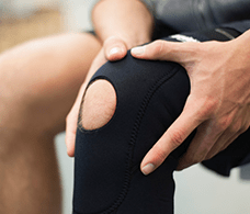 Un patient qui serre une genouillère